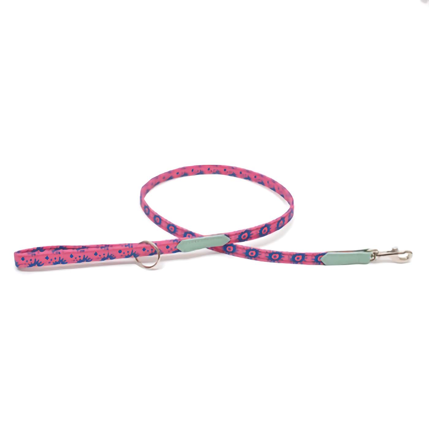 A pink pet leash with a geometric nebula print, featuring a metal clasp and ring, laid out on a white background.