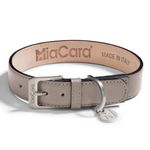 A taupe colored dog collar made from Saffiano leather, branded with 'MiaCara' and 'MADE IN ITALY' on the interior. It features a stainless steel buckle and a D-ring.